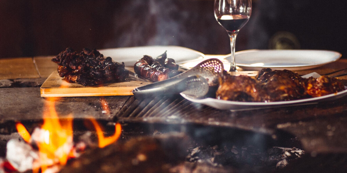 Grillgut auf einem Tisch mit einem Glas Rotwein